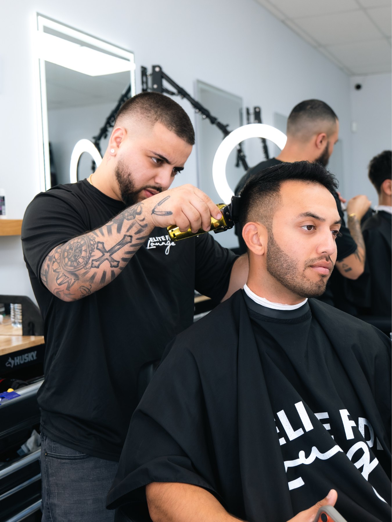 Barber Jerson finishing a clean fade at Elite Fade Lounge